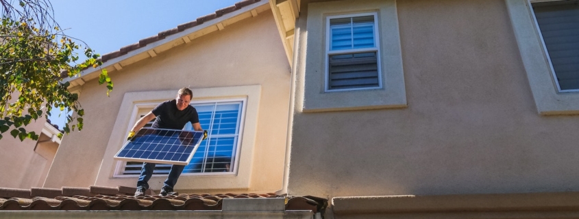 Solar technician installing a solar panel on a residential home in Arizona.